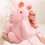 Hands holding a pink dinosaur plush with coral red spikes and ears