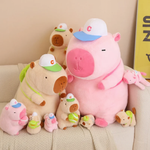Sporty brown and pink capybara plushies in several sizes on a sofa