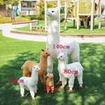 Size comparison of white and brown standing alpaca plushies with cm labels on a lawn