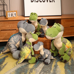 Gray and green T-Rex plush toys in various sizes on a colorful carpet near a wooden dresser.