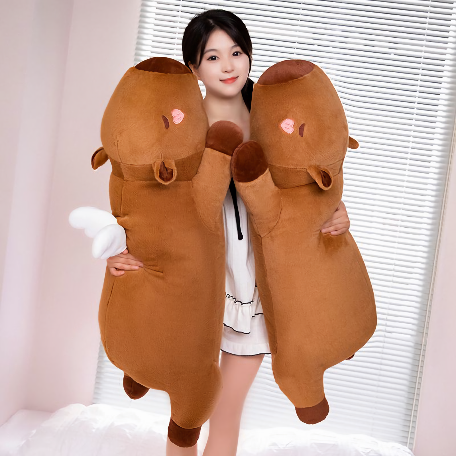 Woman standing and hugging two brown capybara plush pillows
