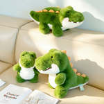 Three green alligator plush toys of different sizes on a sofa