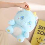 A woman's hand holding a blue fluffy baby dragon plush, showing sparkly star eyes and golden horns.