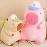 Brown capybara plush and a large pink capybara plush with white caps on a sofa