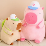 Brown capybara plush and a large pink capybara plush with white caps on a sofa