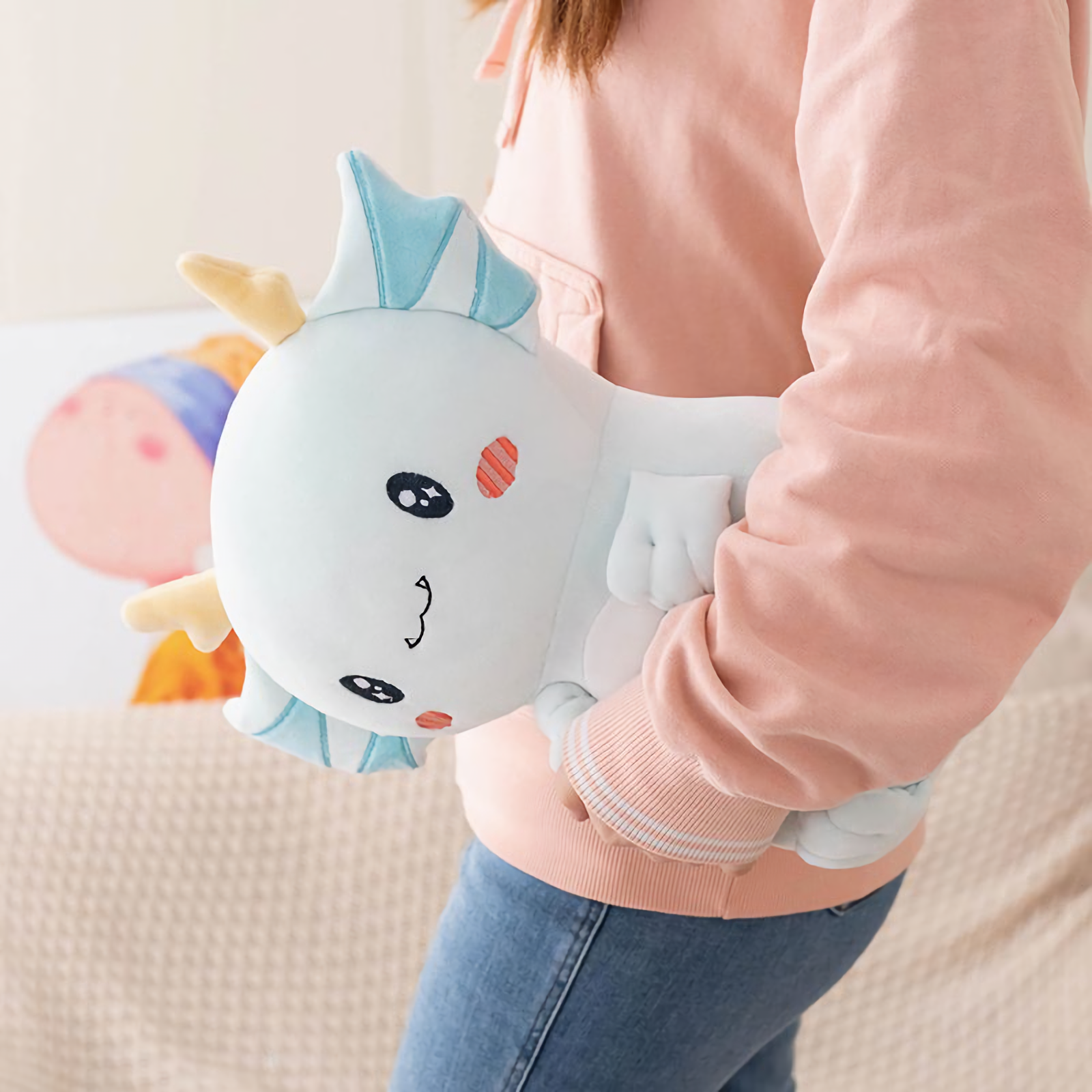 Girl carrying a light blue axolotl dragon plush under her arm