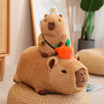 Small capybara plush with a duck sitting on a lying capybara with an orange