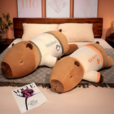 Two lying capybara plush pillows in cream shirts on a bed