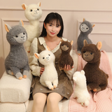 Woman with a group of white, gray and brown fluffy alpaca plushies