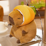 Capybara plush in an orange hood on a metal shelf