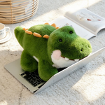 Green alligator plush lying on top of an open laptop