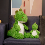 Two green dinosaur plushies without bags sitting on a sofa