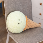 Mint green ice cream cone plush pillow lying on a gray chair