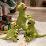 Three green Tyrannosaurus Rex plush toys of different sizes on a carpet near wrapped gifts under a tree.