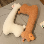White and brown long alpaca plush pillows lying on a bed