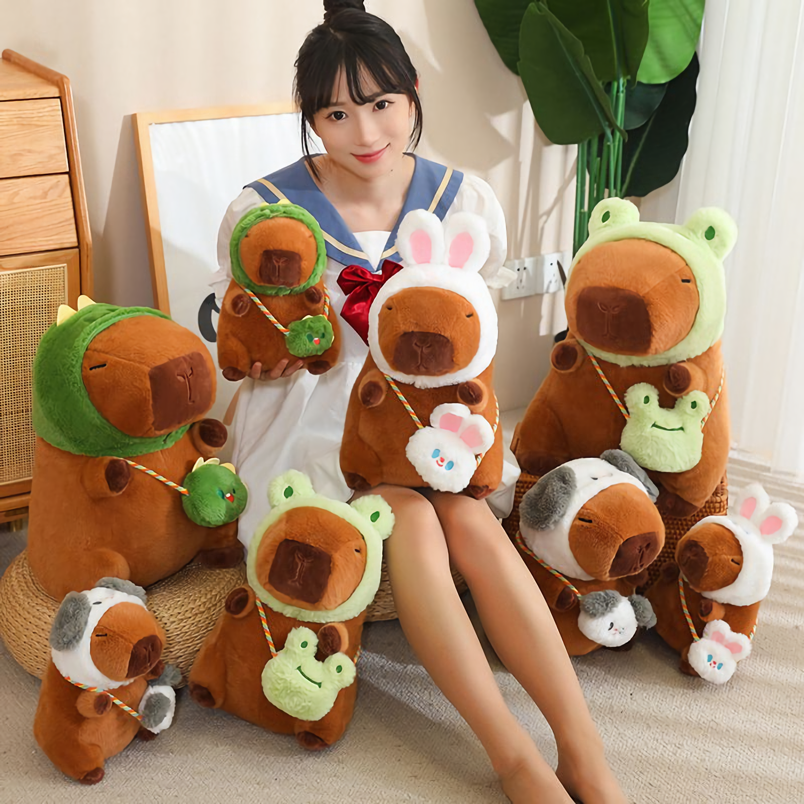 Woman with a group of hooded capybara plushies and lotus leaf capybaras on the floor