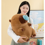 Woman holding a brown capybara plush with a blue nose bubble