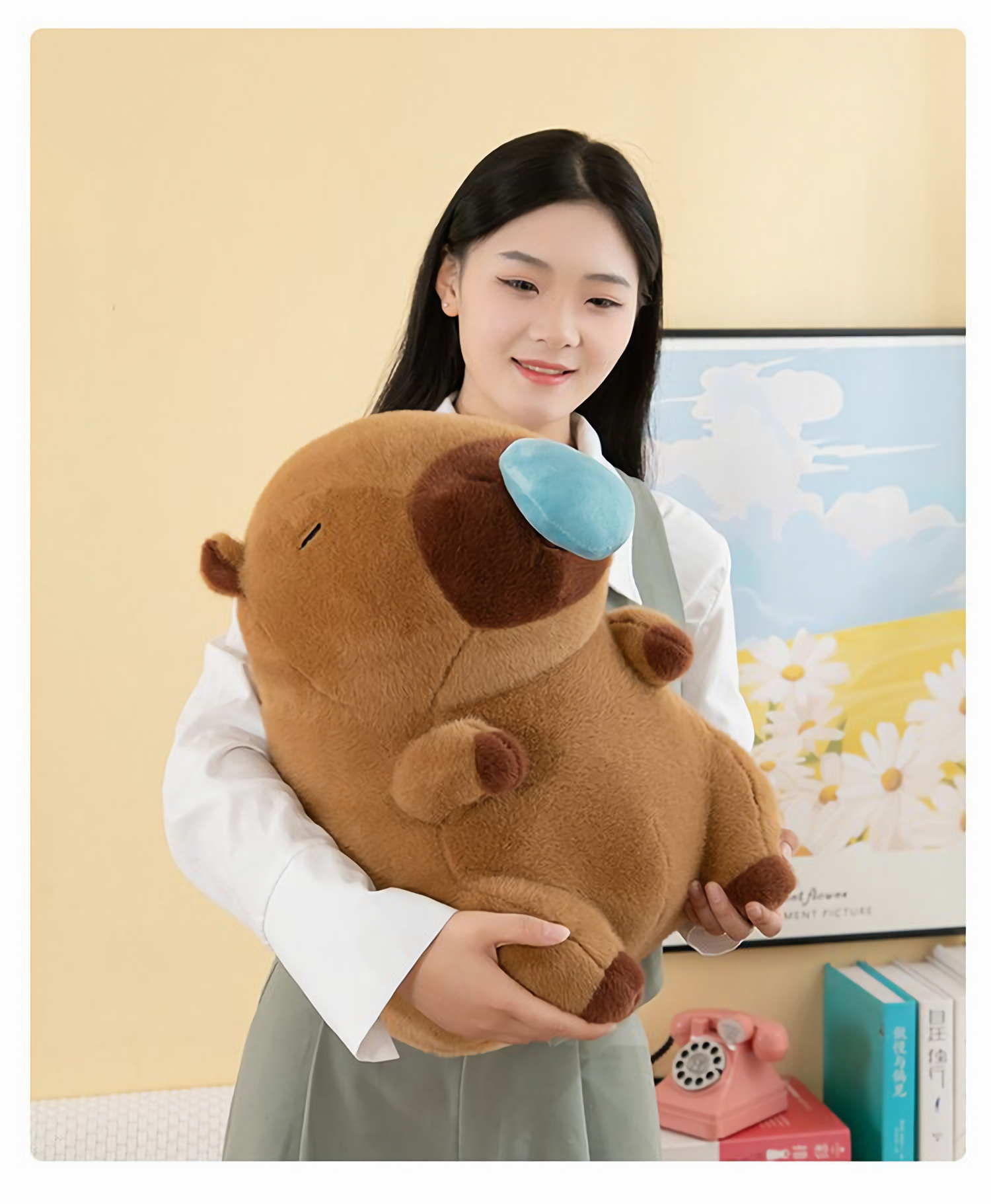 Woman holding a brown capybara plush with a blue nose bubble