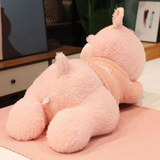 Back view of a pink sleeping sheep plush pillow lying on a bed