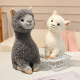 Gray and white fluffy alpaca plushies next to a white wire basket