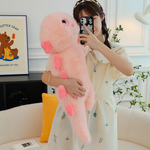 Woman hugging pink dinosaur plush pillow with heart-shaped back spikes, indoor setting with sofa and plants.