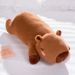 Lying brown capybara plush pillow with a sleepy face on a white bed