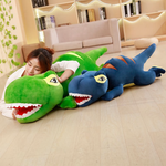 Woman lying on the floor with a blue T-Rex plush pillow and a green one