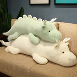 Mint green and white dragon plush body pillows stacked on a sofa.