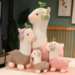 Group of pink and gray alpaca plushies with headphones and leaf sprouts on a bed