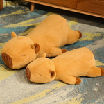 Two lying capybara plush pillows on a patterned rug