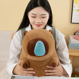 Woman looking at a brown capybara plush with a blue nose bubble on her lap