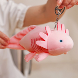 Woman holding a pink axolotl plush by a clip ring