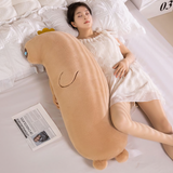 Woman resting on a bed with a long tan capybara body pillow