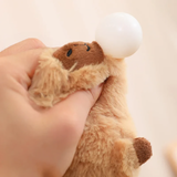 Hand squeezing the white nose bubble of a capybara plush
