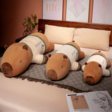 Three lying capybara plush pillows in different sizes on a bed
