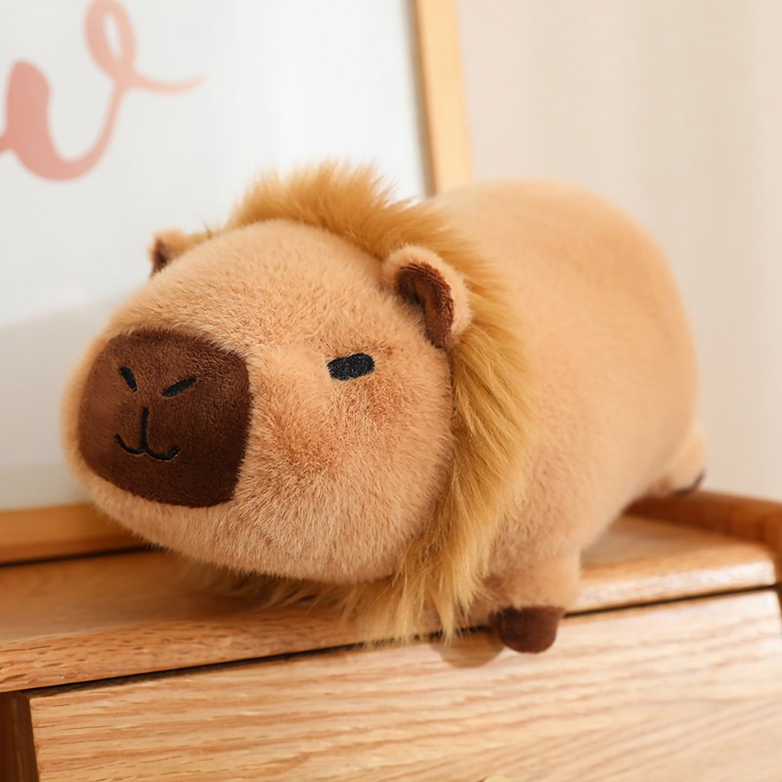 Lion capybara plush with a fluffy mane on a wooden shelf