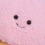Close-up of the smiling face on a pink ice cream plush pillow