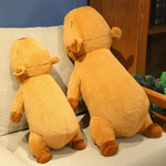 Two standing capybara plush pillows on a gray sofa