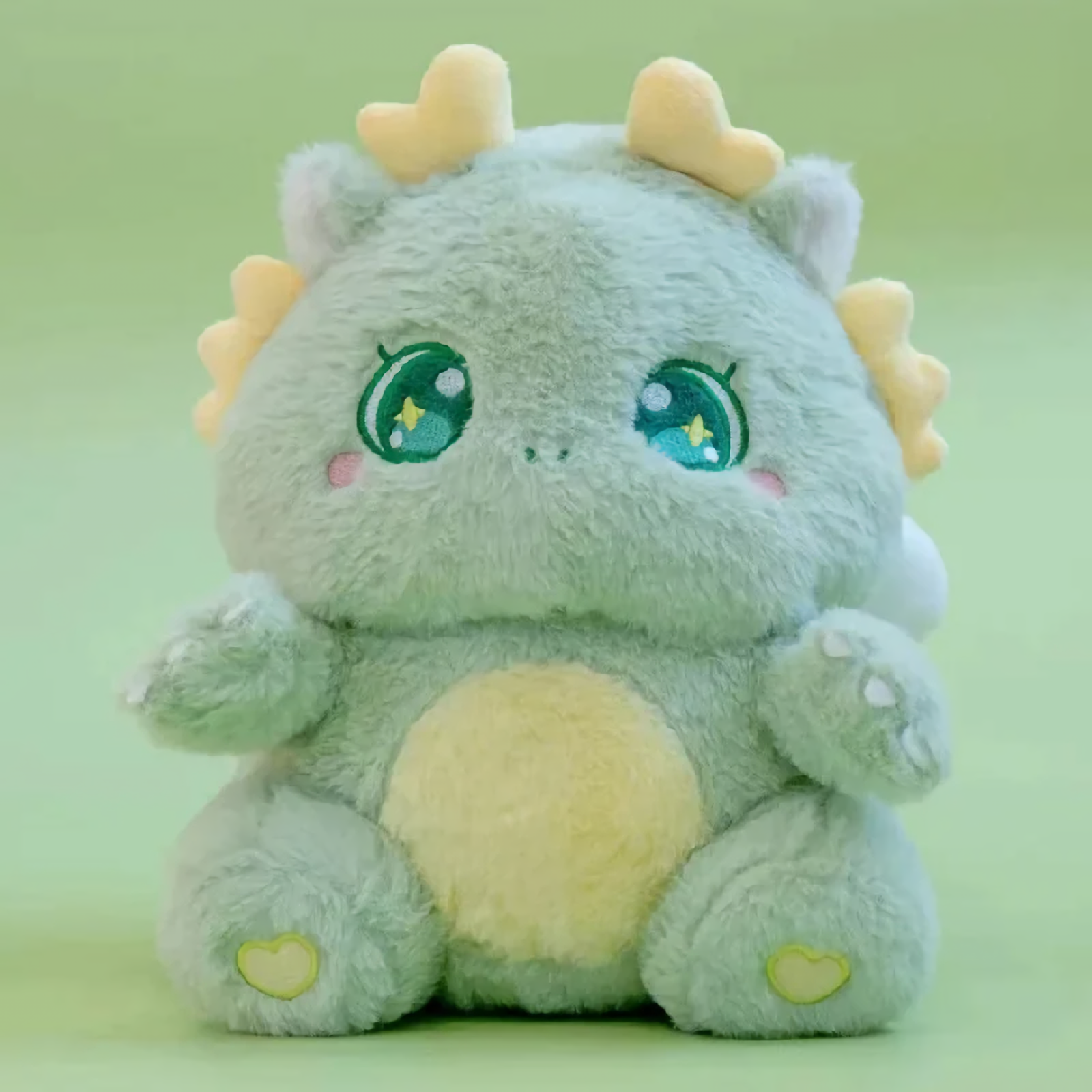 Green Kawaii Baby Dragon Plush with golden horns and sparkly star eyes, sitting against a soft green background.