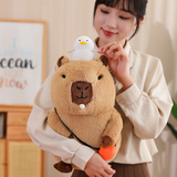 Woman hugging a capybara plush with a white duck on its head