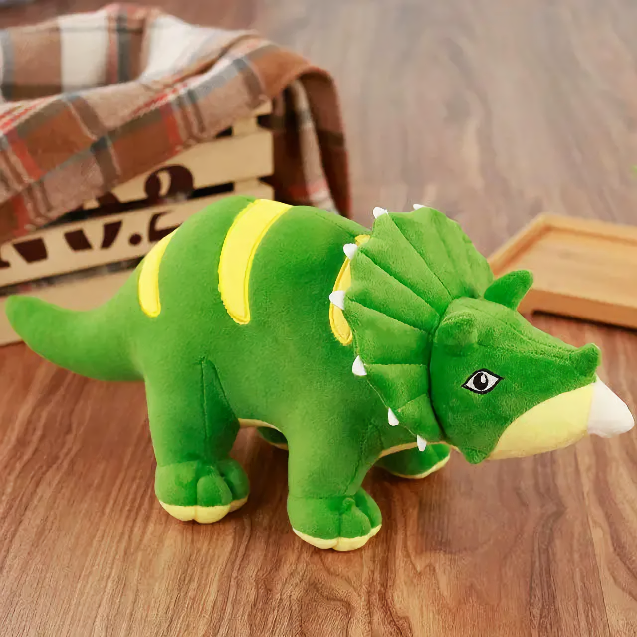 Green Triceratops dinosaur plush with a frill on a wooden floor