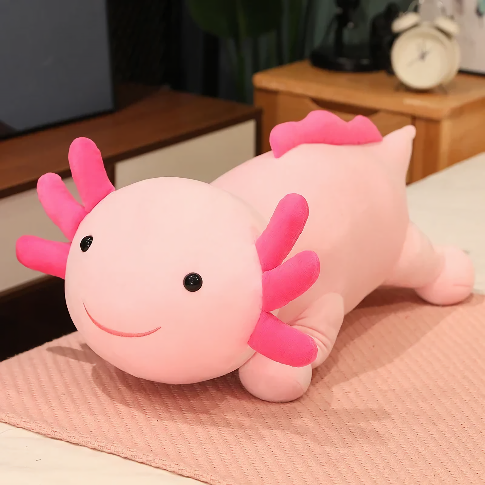 Pink axolotl plush pillow with bright pink gills and a smiling face
