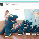 Woman with 2.1m blue and green T-Rex plush beside smaller plush sizes, in a room with a world map wall.