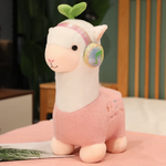 Pink alpaca plush with rainbow headphones and a leaf sprout on a bed