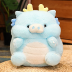 Blue Kawaii pig-dragon plush with cream belly on a woven mat, showing its fluffy round body and tiny horns.