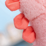 Close-up of the coral red spikes on a pink dinosaur plush