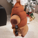Person lifting a capybara plush with a brown swirl hat and sunglasses hanging down