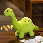 Green Brontosaurus plush with smiling face on a wooden table, next to a newspaper.