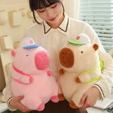 Woman holding a pink and a brown sporty capybara plush
