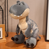Gray T-Rex plush with cream belly and subtle stripes, standing on a wooden surface.